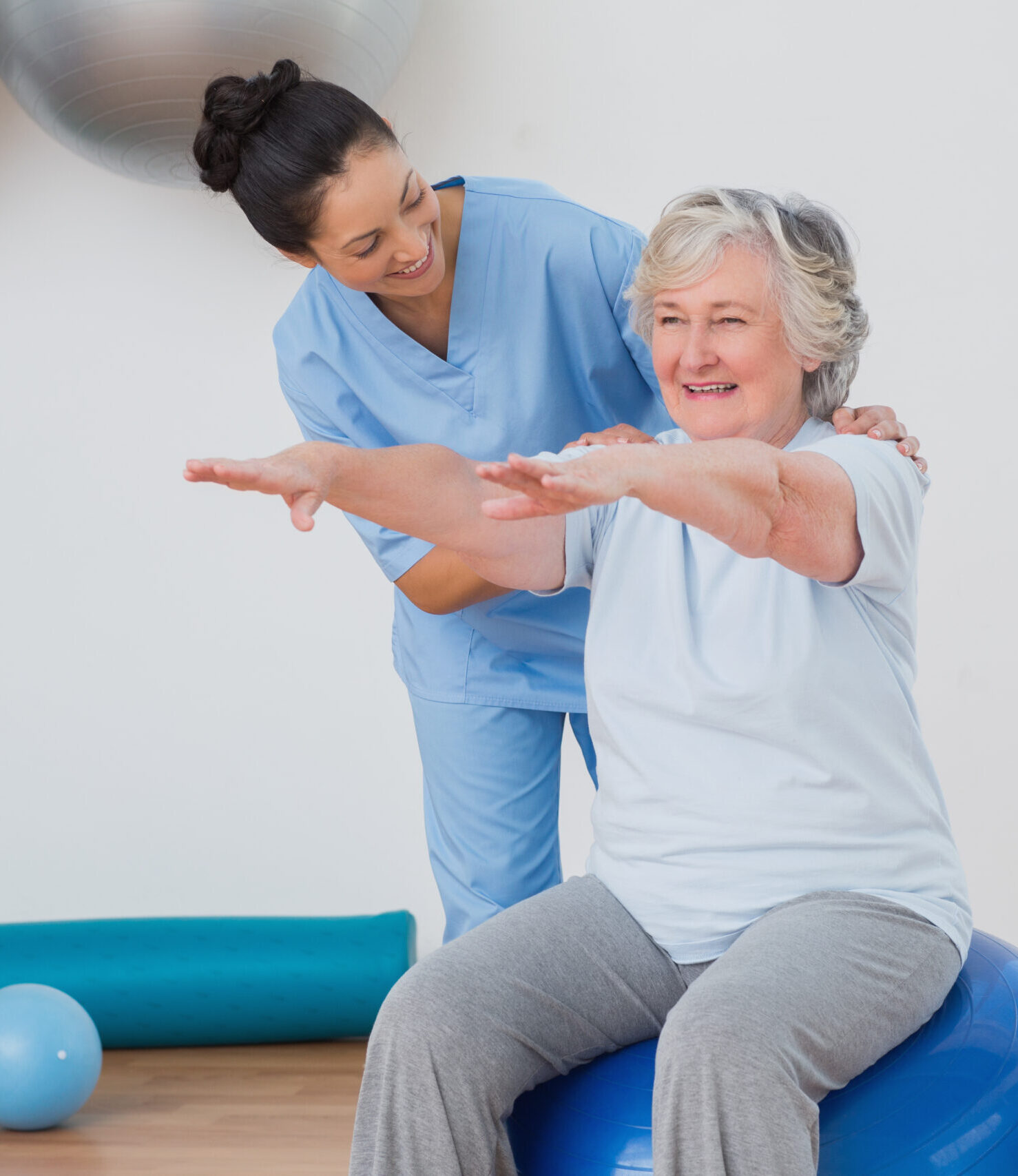 Instructor assisting senior woman in exercising Physical Therapy